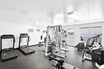 the view of a fitness room with cardio equipment